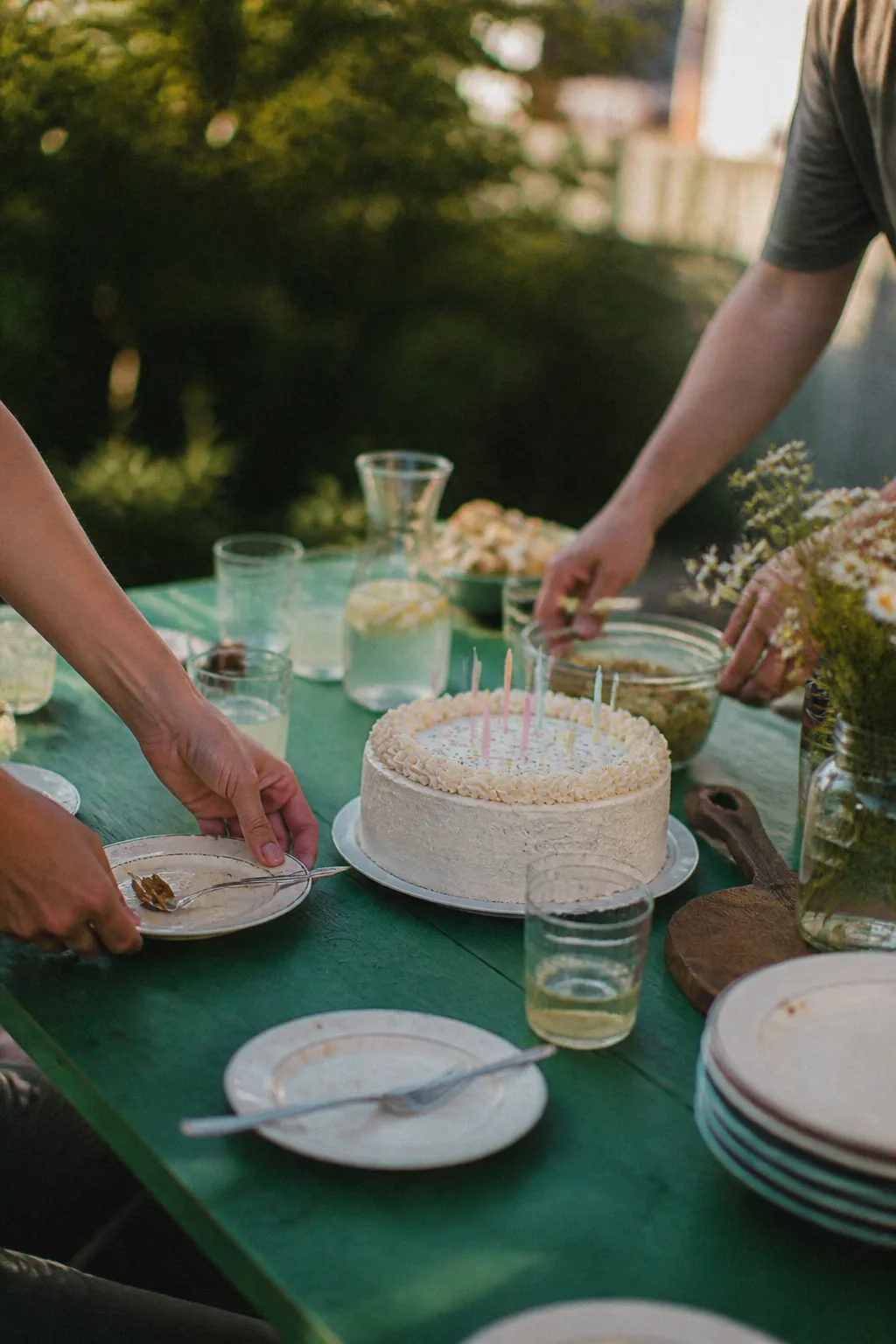 Geburtstagstafel mit Kuchen und kleinen Snacks im Garten